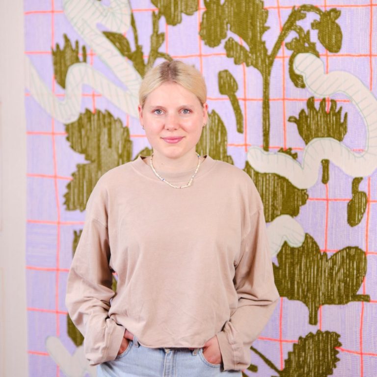 Die Künstlerin Judith Kaminski steht vor einem ihrer Werke.